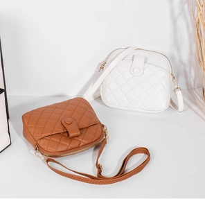 Close-up of brown and white quilted shell bags with zipper and flap closure details