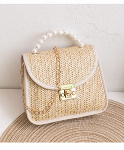 Close-up of pearl bead handle and woven texture on mini straw crossbody bag