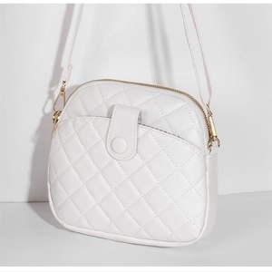 Detail of white quilted shell bag with gold zippers and front snap pocket detail