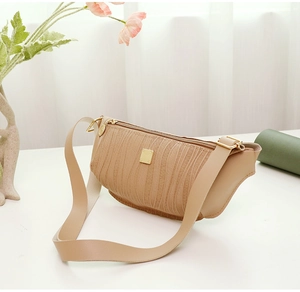 Dettaglio della borsa beige che mostra la trama a onde e la cerniera in metallo dorato