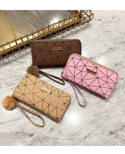 Tre portafogli lunghi in pelle PU con stampe geometriche e ciondolo a pompon su marmo