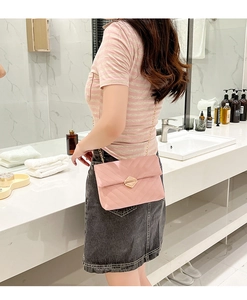 Detailed close-up of pink V-quilted chain bag with gold rotating lock and fine strap