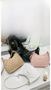 Detail showing elegant quilted embroidery patterns and gold chain straps on four stylish handbags