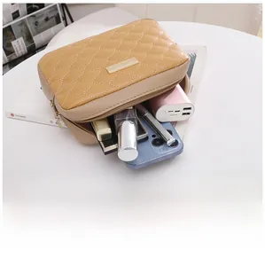 Detail of khaki quilted handbag with metallic zipper and inner storage for cosmetics