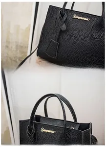 Detail view of black litchi texture leather handbag with branded logo and stylish charm