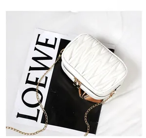 Détail du sac matelassé blanc avec bandoulière chaîne et double fermeture sur tissu