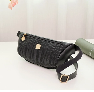 Dettaglio borsa da petto nera da donna con trama a pieghe ed eleganti elementi dorati