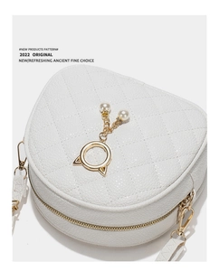 Detailed top view of white heart-shaped crossbody bag with quilted pattern and pearl cat ears