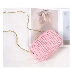 Détail d'un sac bandoulière en cuir matelassé rose avec élégante chaîne dorée