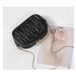 Détail du sac bandoulière plissé noir avec double fermeture éclair et chaîne dorée