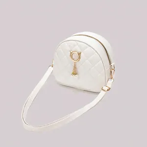 White quilted crossbody bag with golden cat-ear ring and pearl tassel charm decoration