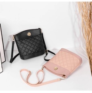 Detail of quilted leather bucket bags in black and pink with golden sunburst buckle