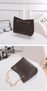 Detail of dark brown bucket bag with circular pattern and gold chain strap in a home setting
