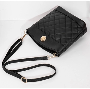 Detail of black quilted bucket bag featuring a gold rhinestone buckle and fine leather texture