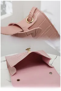 Détails du petit sac rose façon croco avec fermoir doré et espace de rangement interne