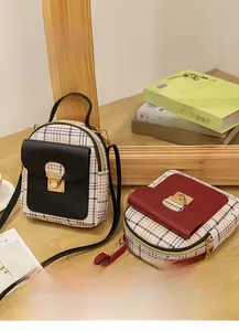 Detail of vintage plaid mini backpacks with gold metal locks on wooden display stand