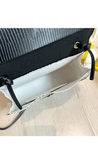 Vue détaillée montrant la grande capacité et le motif lézard du sac noir bandoulière