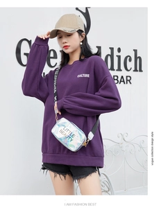 Outdoor shot of a silver laser crossbody bag paired with a purple oversized sweatshirt