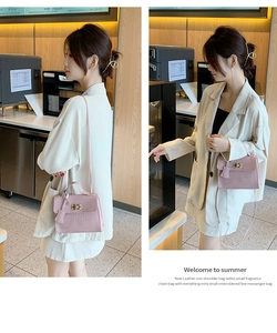 Gros plan du sac en cuir PU rose à motif crocodile avec fermoir rotatif doré en métal