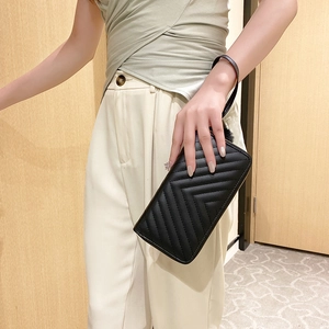 Women's black quilted leather long clutch purse with chevron pattern and wristlet strap