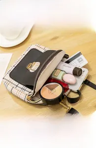 Close-up of small crossbody bag showing interior storage for phone and cosmetics