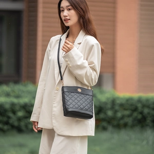 Elegant black quilted bucket bag with golden logo and thin strap for women's daily commute
