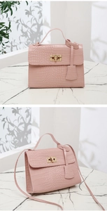 Détail du sac bandoulière rose à motif crocodile avec fermoir rotatif doré élégant