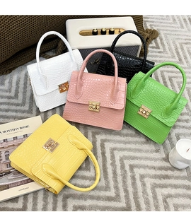 Detail view of five luxury crocodile pattern handbags with elegant gold metal square locks