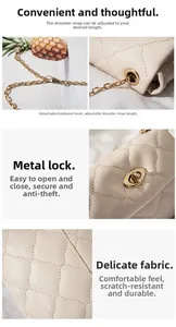 Detail of quilted leather texture, metal swivel lock, and adjustable chain strap on bag
