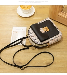 Detail of checkered mini crossbody bag with gold buckle on a wooden table setup