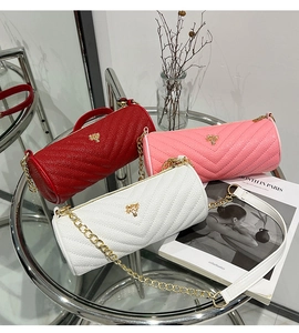 V-quilted barrel crossbody bags in red, pink, and white with gold chain and tree charm