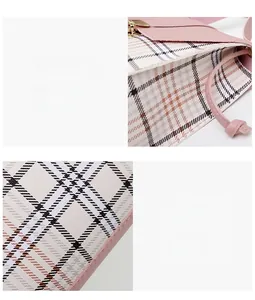 Detailed view of pink plaid bag fabric with precise stitching and metal clasp