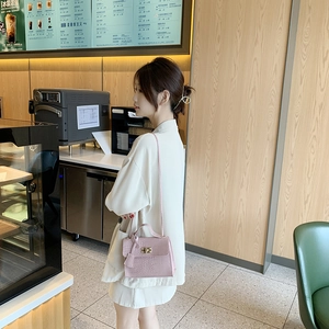 Elegant pink crocodile pattern leather handbag with gold twist lock and shoulder strap