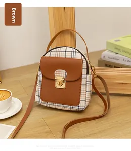 Detailed close-up of a brown plaid mini backpack with premium metal buckle and leather flap