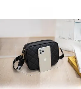 Detail view of black quilted crossbody bag with logo strap and size specs 18x13.5x6 cm