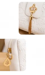 Detailansicht der weißen PU-Ledertasche mit Goldkronen-Quaste und Blatt-Reißverschluss