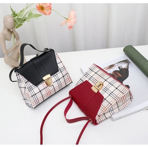 Detail of plaid patterned handbags with gold metal closures and top handles for women