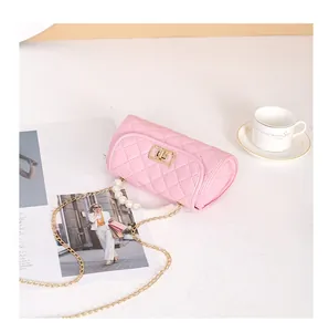 Détail d'un sac à main en cuir matelassé rose avec poignée en perles et fermoir doré
