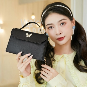 Black mini leather tote bag with white butterfly buckle and golden chain strap