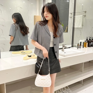 Short sleeve houndstooth blazer paired with a quilted white baguette shoulder bag