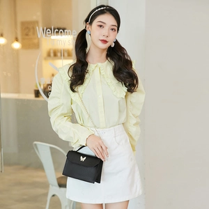 Minimalist black leather square handbag with golden butterfly clasp shown on model