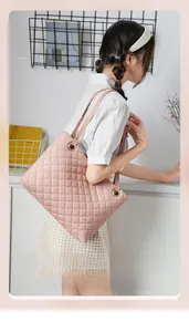 Pink quilted tote bag with diamond stitching and gold ring hardware shown on shoulder