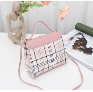Detail shot of the pink plaid pattern and soft leather handle of this stylish handbag