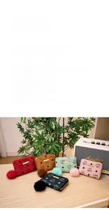 Short zipper wallets in five colors featuring printed patterns and plush ball pendants