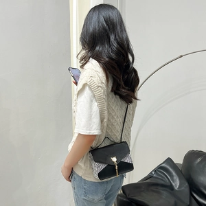 Sac bandoulière avec imprimé zébré et gland métallique porté par un mannequin pour le style