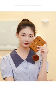 Brown short zipper wallet with LBS logo pattern and soft plush ball charm accessory