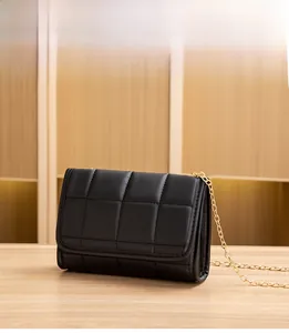 Close-up of black quilted chain crossbody bag featuring classic diamond pattern leather