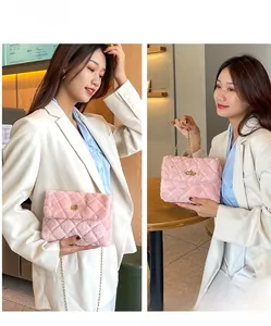 Close-up of pink plush quilted crossbody bag with golden chain strap and twist lock