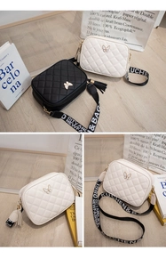 Close-up of quilted crossbody bag with metal butterfly buckle and tassel detail