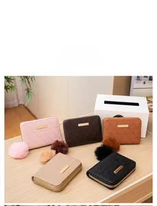 Flat lay of five quilted coin purses in various colors with metallic accents and pom-poms